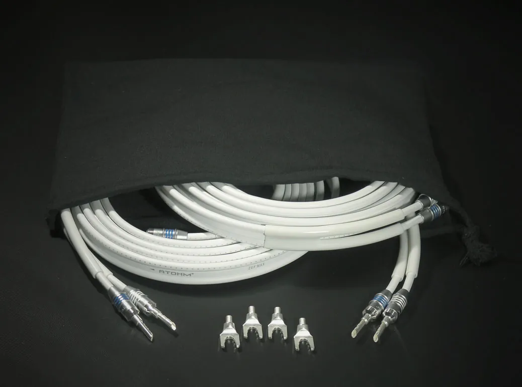 Atohm ZEF Max Set — paire de câbles blancs terminés par des fiches, avec fourches, posée sur sa housse noire